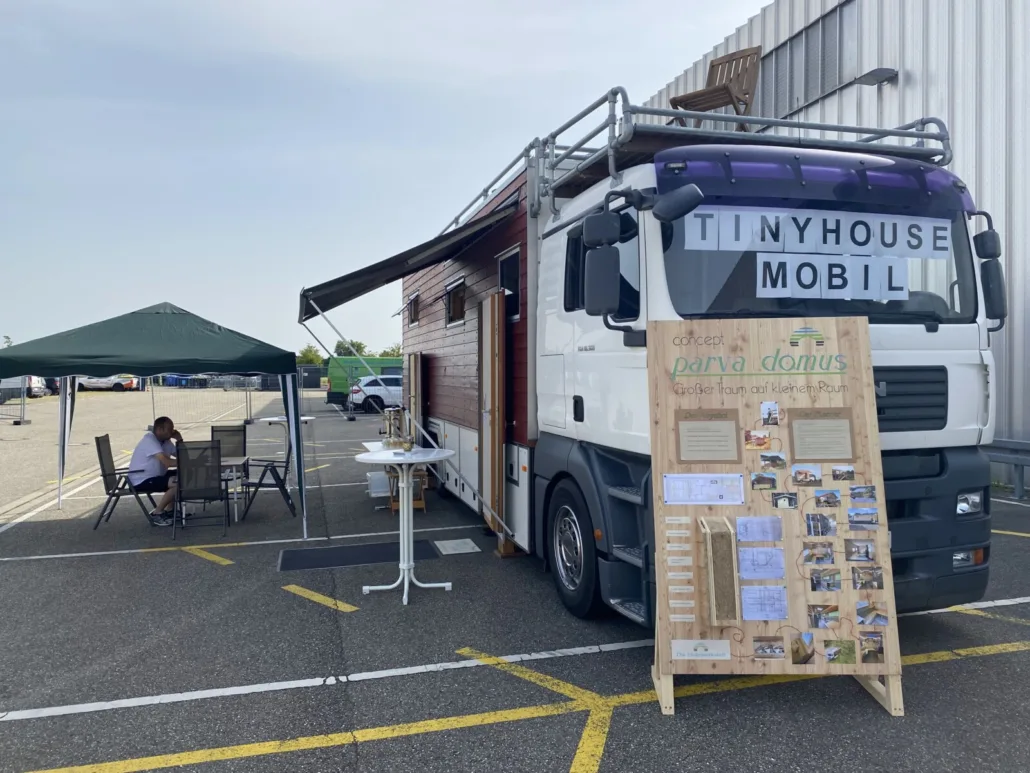 Frontansicht mit TINYHOUSE-MOBIL-Schild und parva-domus-Kundenstopper