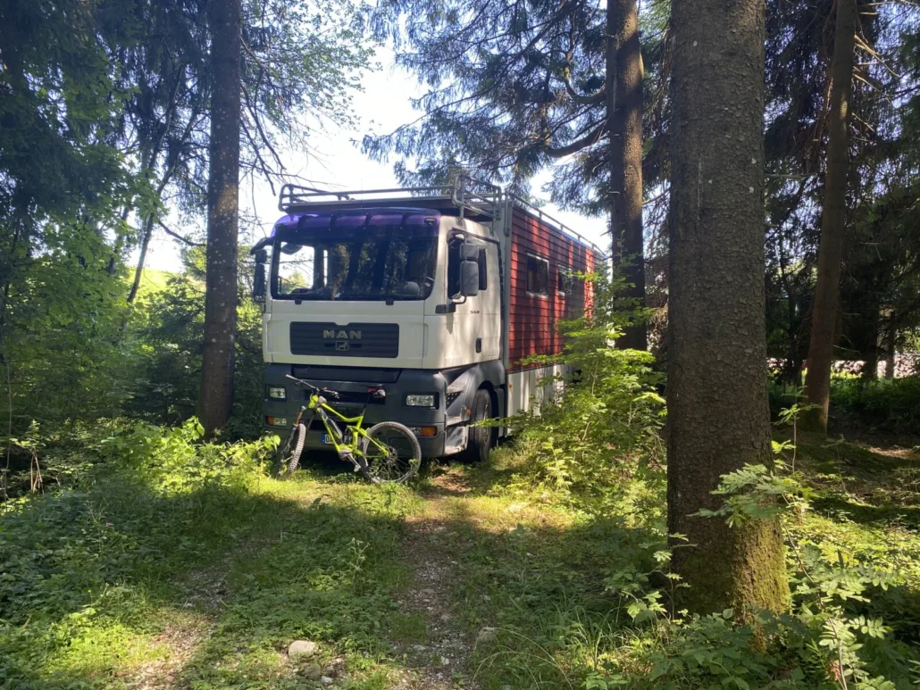 Mit rotem Holzaufbau und Mountainbike am Waldweg