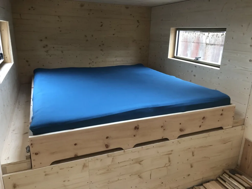 Einbaubett aus Massivholz im holzverkleideten Schlafbereich