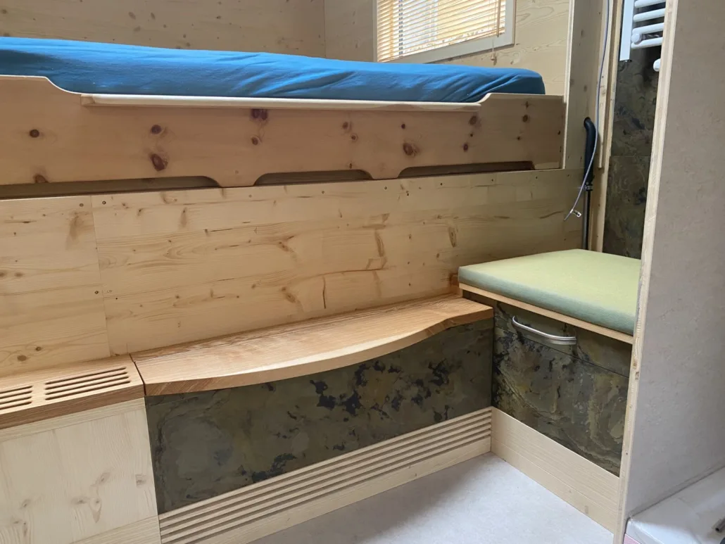 Hochbett über Sitzbank und Staufächern aus Holz