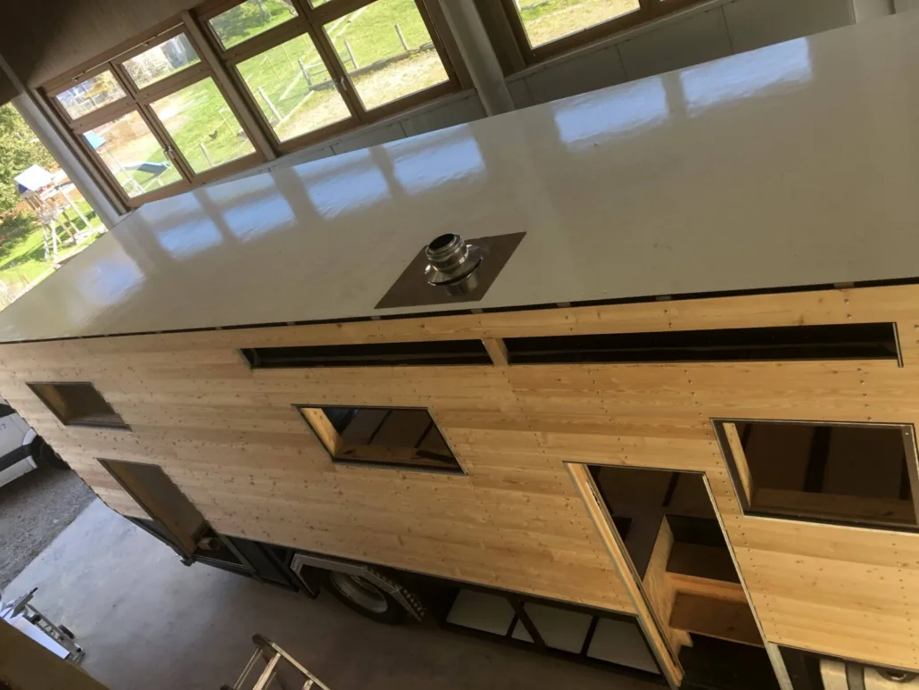 Holzfassade mit montierter Schornsteindurchführung auf dem Dach