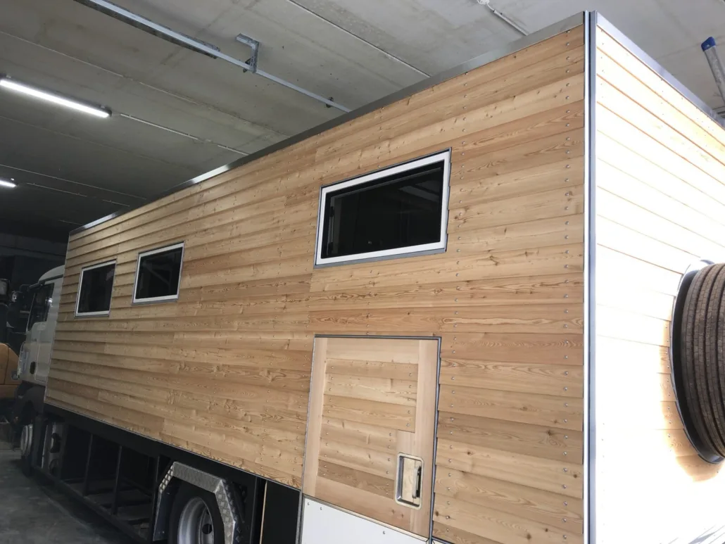 Fertig verschalte Längswand mit drei Fenstern und Holztür