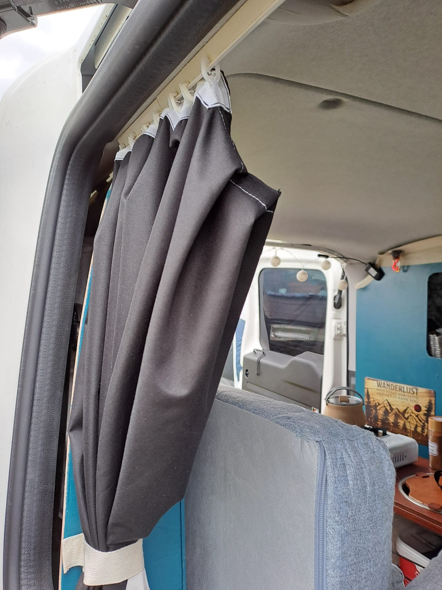 Sofa-Seite mit Vorhang und blauer Sperrholzwand