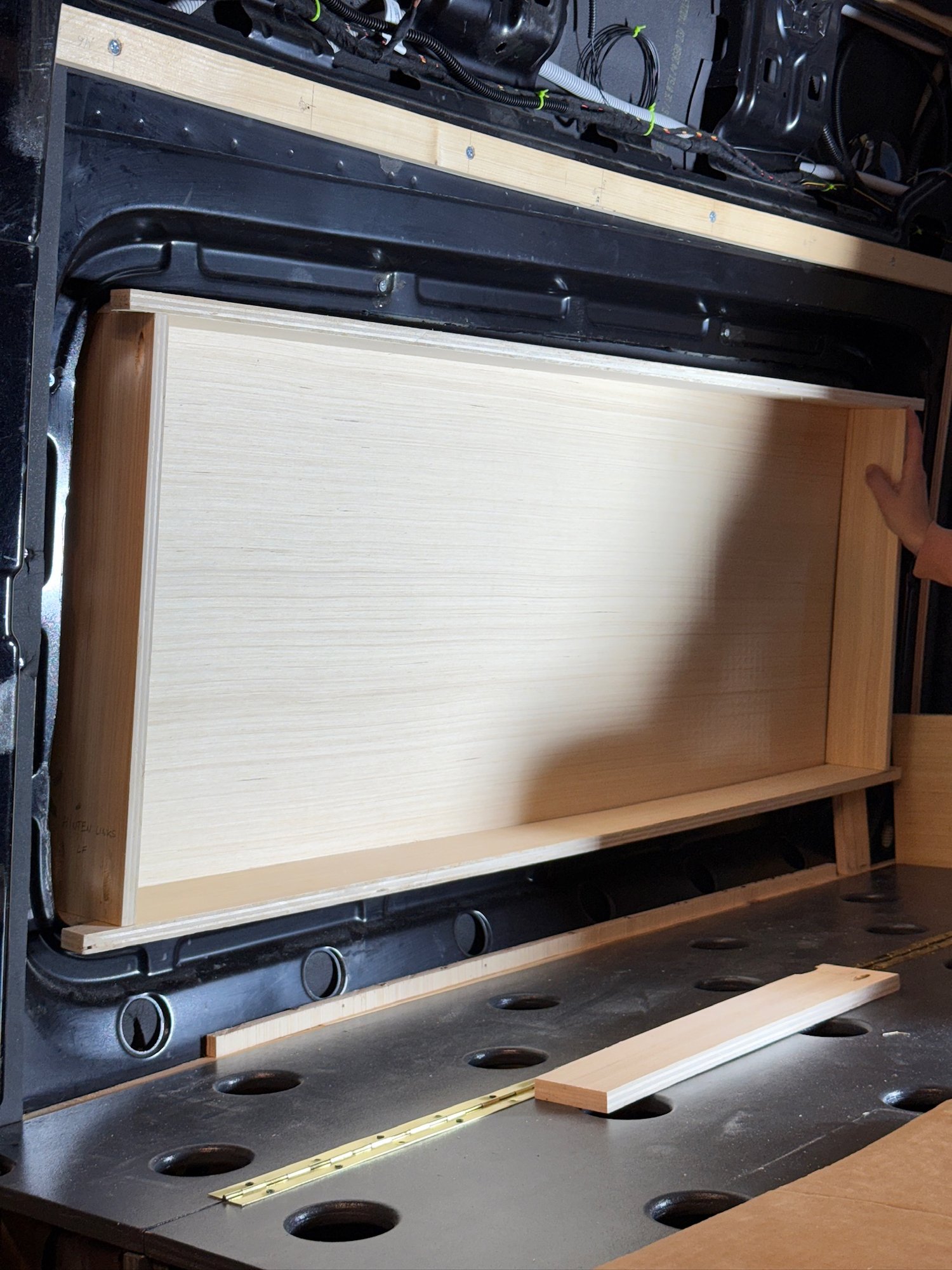 Die selbst gebaute Holzverkleidung beim Anpassen — erst nach ein paar Anläufen lag sie an